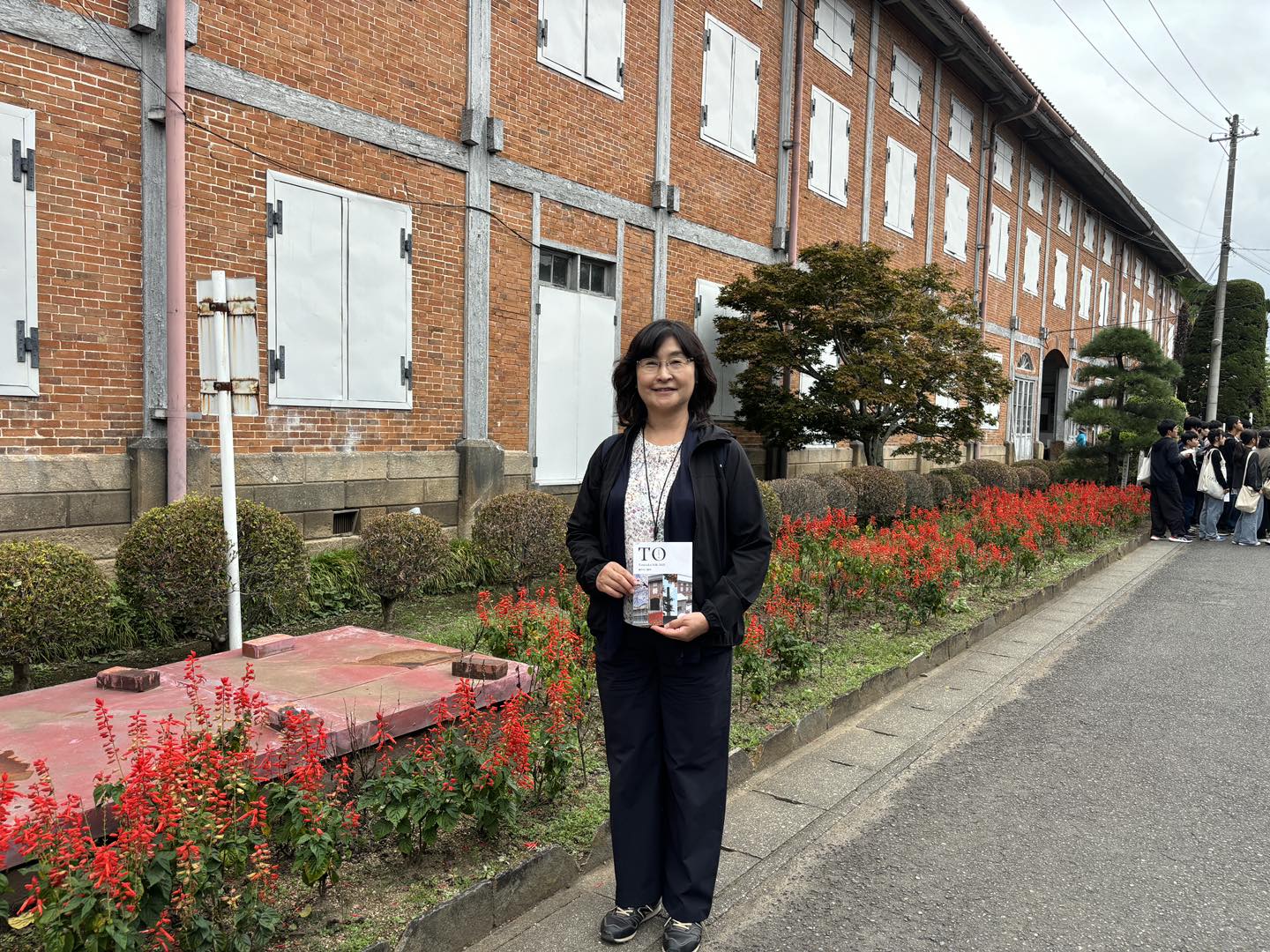 赤レンガの建物を背景に立つ来訪者(富岡製糸場)
